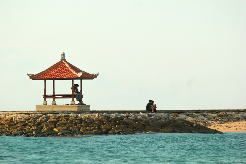 A gazebo sitting atop a rock breakwater